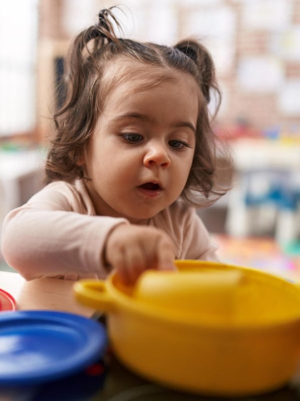 adorable-hispanic-girl-playing-with-play-kitchen-standing-kindergarten_839833-12126